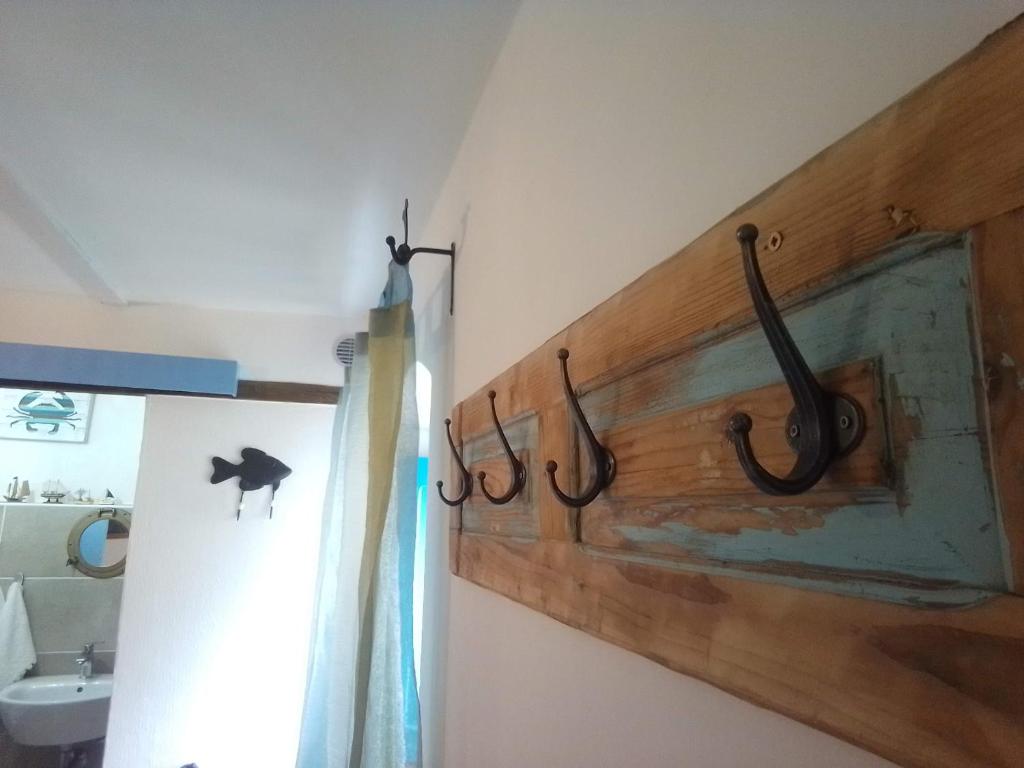ein Badezimmer mit einer Holzwand mit Haken an der Wand in der Unterkunft Piccola Casa Di Sardegna in Villanova Monteleone