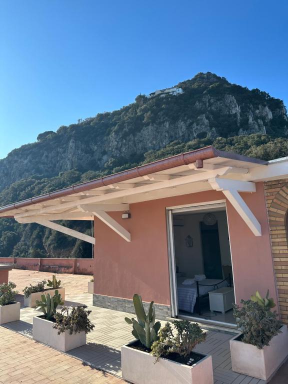 a house with a mountain in the background at The RoofPort in San Felice Circeo
