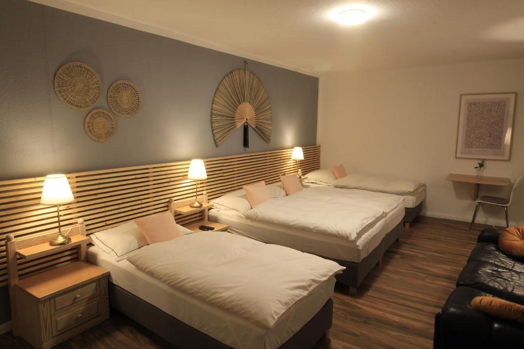 Habitación de hotel con 2 camas y sofá en Zimmer AsiaDreieck Pension en Lauterecken