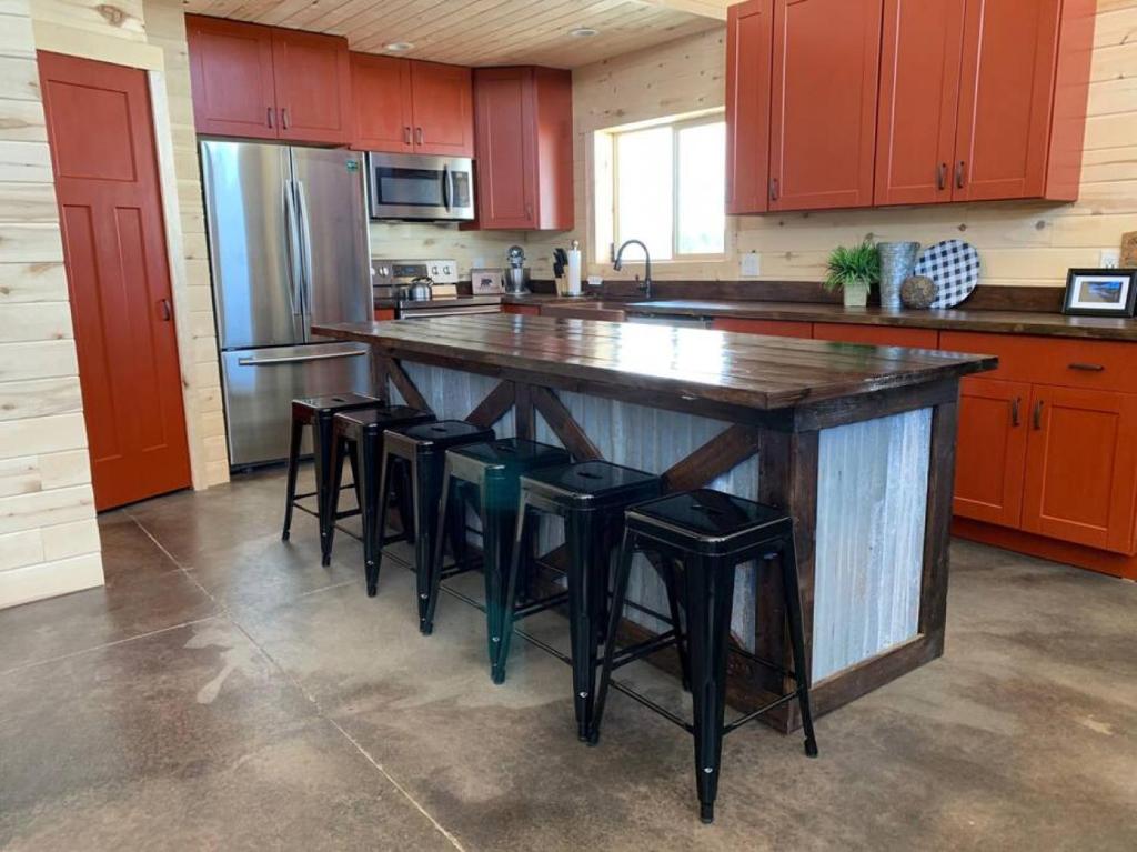 a kitchen with a large wooden island with stools at Newly Built, Fire Pit, Kitchen in Rea
