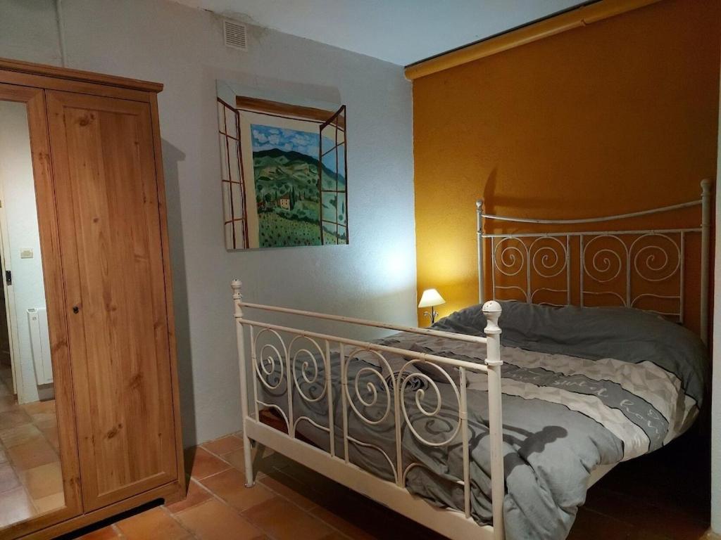 a bedroom with a bed with a wooden headboard at Mas Chamarel à Sanary-sur-Mer au milieu des vignes et oliviers in Sanary-sur-Mer