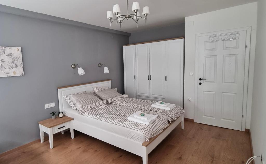 1 dormitorio con cama blanca y puerta blanca en Good morning Ohrid, en Ohrid
