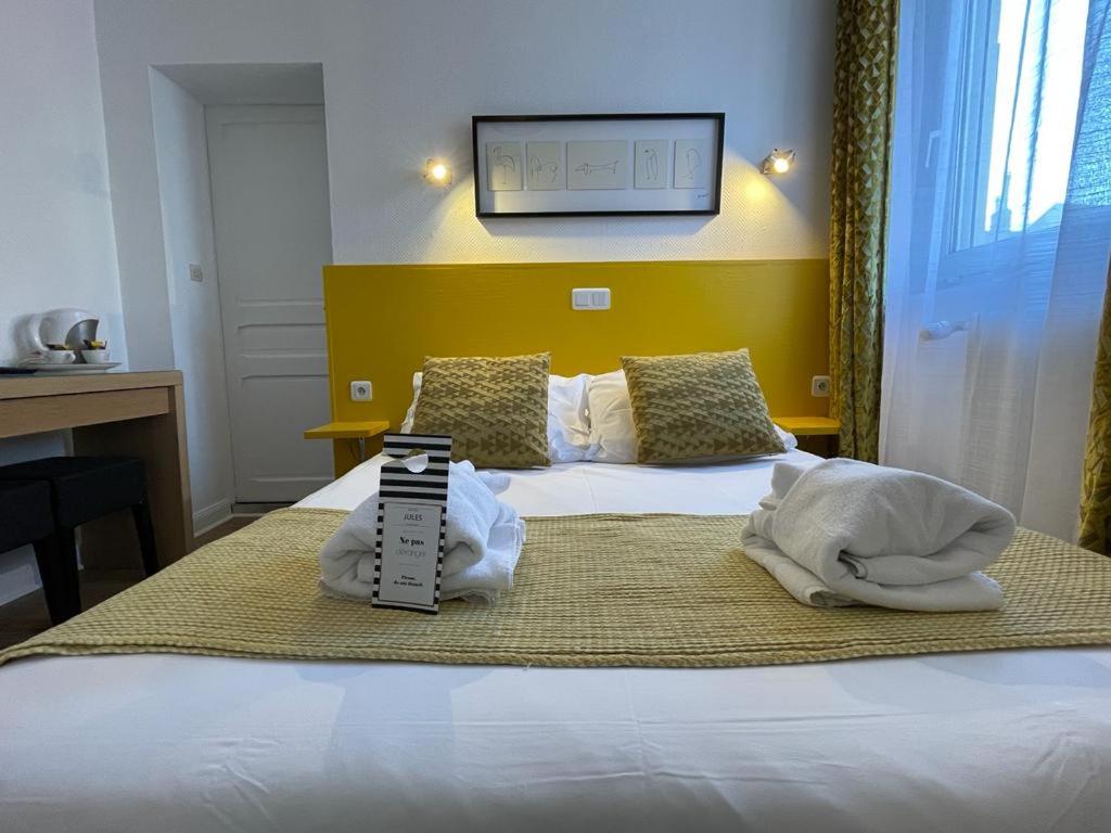 a hotel room with a bed with towels on it at Hôtel Jules in Le Touquet-Paris-Plage