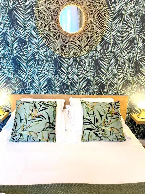 a bedroom with a bed and a wall with a mirror at Hôtel Jules in Le Touquet-Paris-Plage