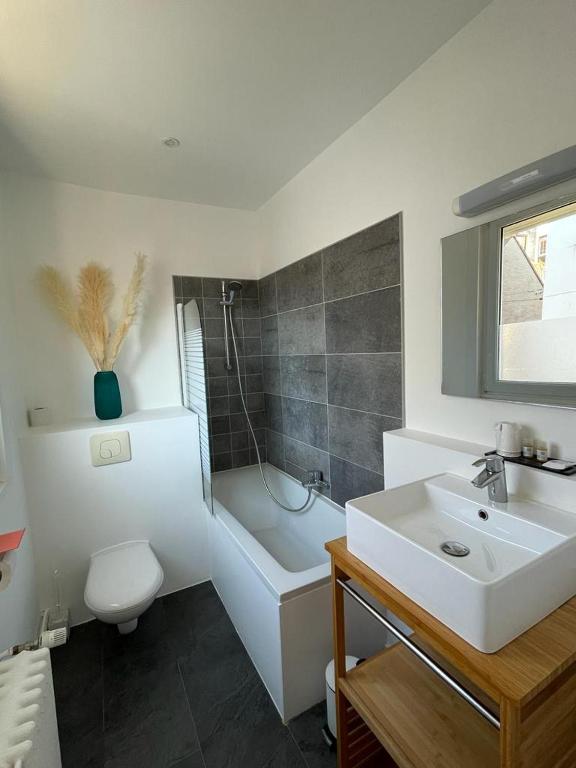 a bathroom with a sink and a tub and a toilet at Hôtel Jules in Le Touquet-Paris-Plage