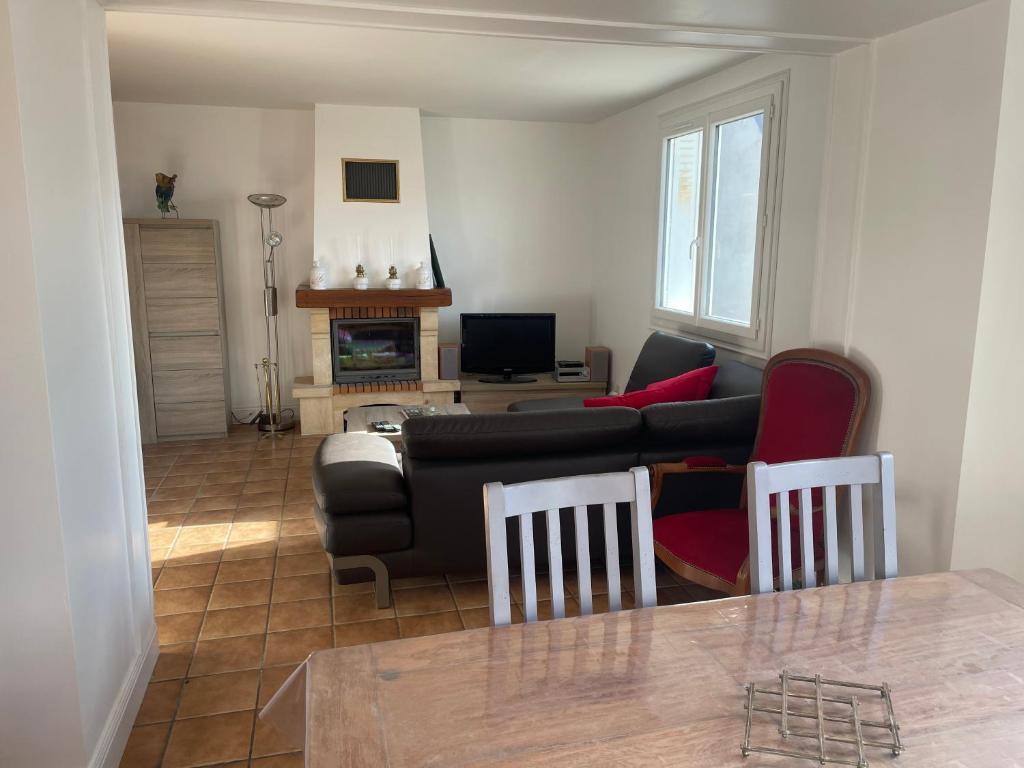 a living room with a black couch and red pillows at Gîte des Buis in Moutier-Rozeille