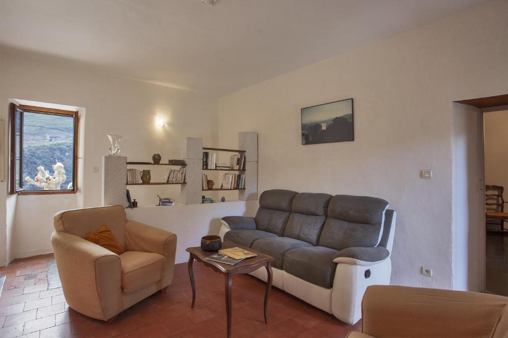 a living room with a couch and a chair at Casuccia in Santo-Pietro-di-Tenda