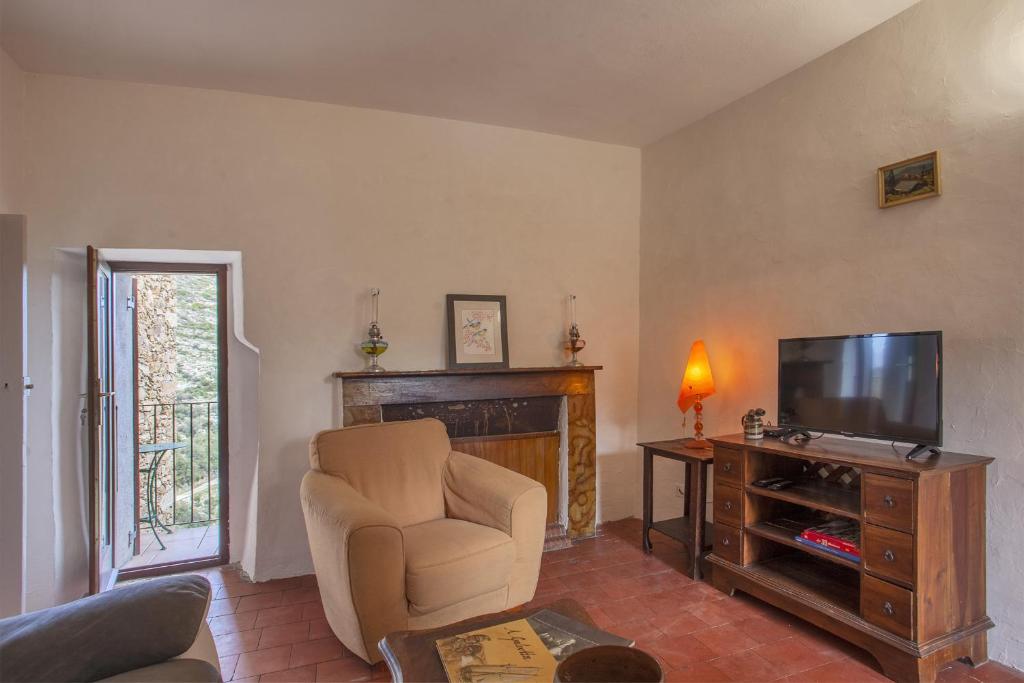 a living room with a chair and a television at Casuccia in Santo-Pietro-di-Tenda