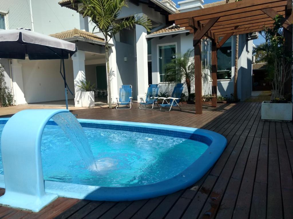 una piscina azul con una fuente de agua en Linda casa com piscina e 4 suites no mariscal a 100 metros da praia, en Bombinhas