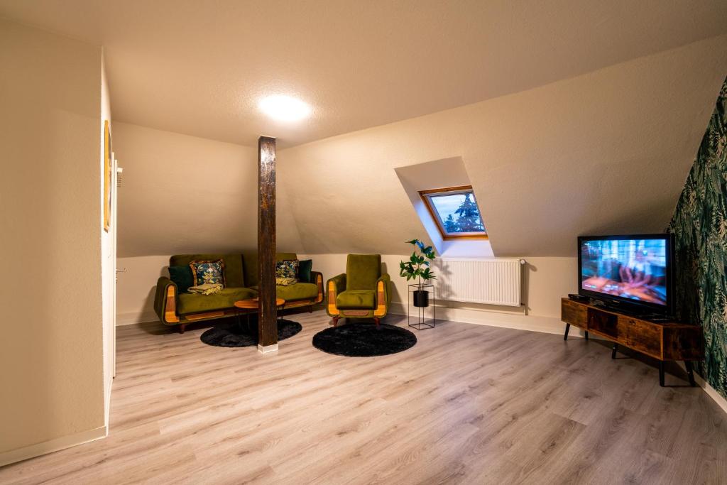 a living room with a couch and a tv at Bördeapartment am Heiderand 