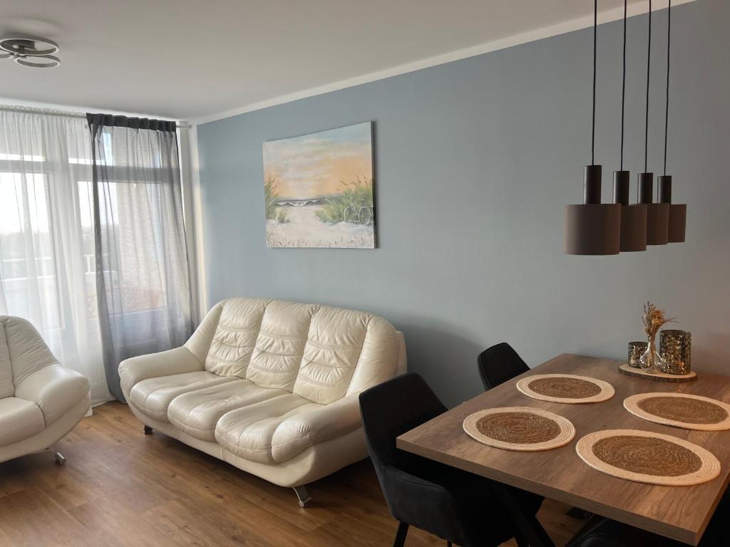 sala de estar con sofá y mesa de comedor en Ostsee Ferienwohnung in Sierksdorf - Hansa Park en Sierksdorf