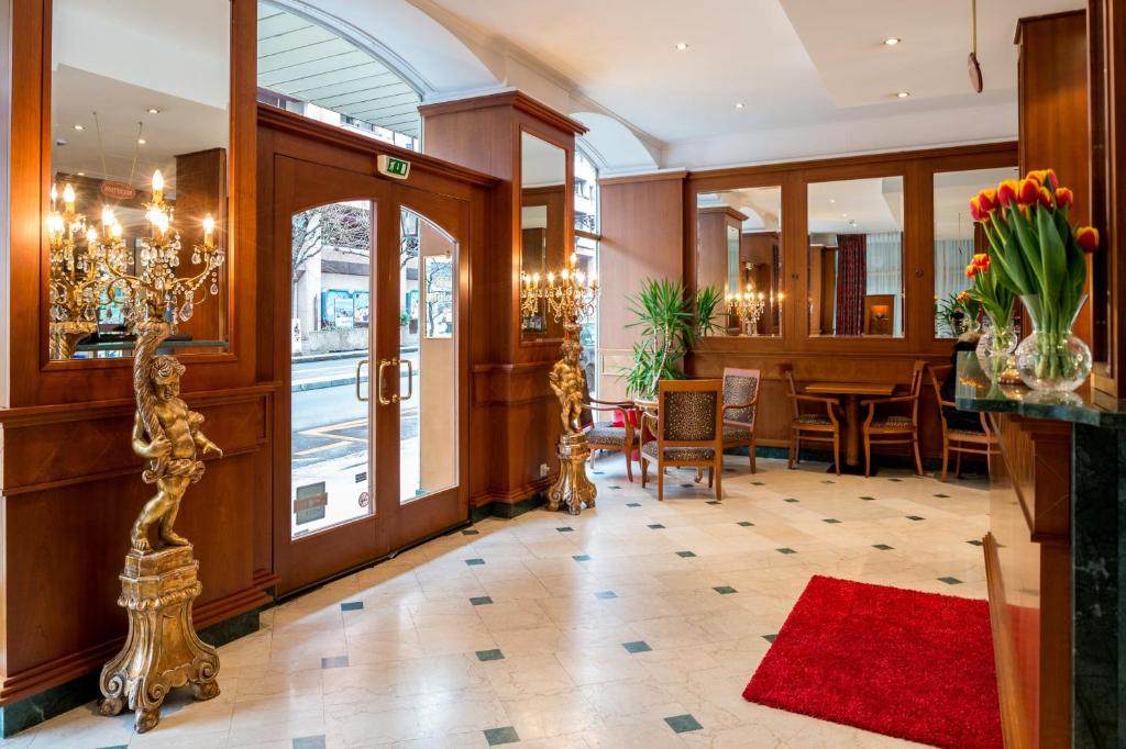 a lobby of a hotel with a table and chairs at Hotel Diplomate in Geneva