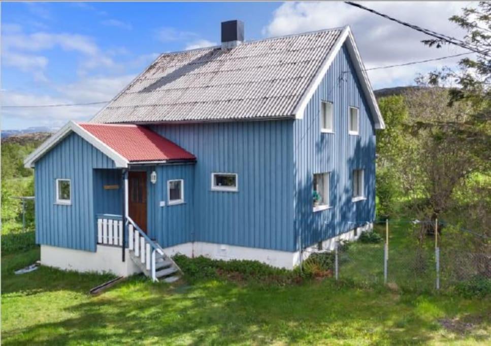 una casa azul con techo rojo en Paul's House, en Saltstraumen