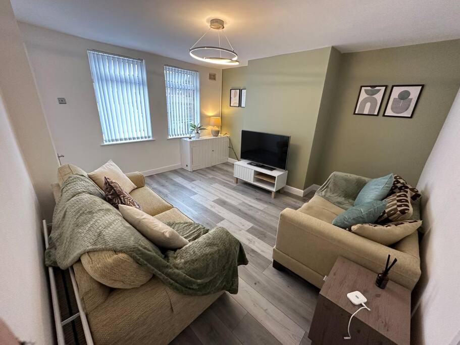 a living room with two couches and a television at MMC Serviced accommodation in Leigh