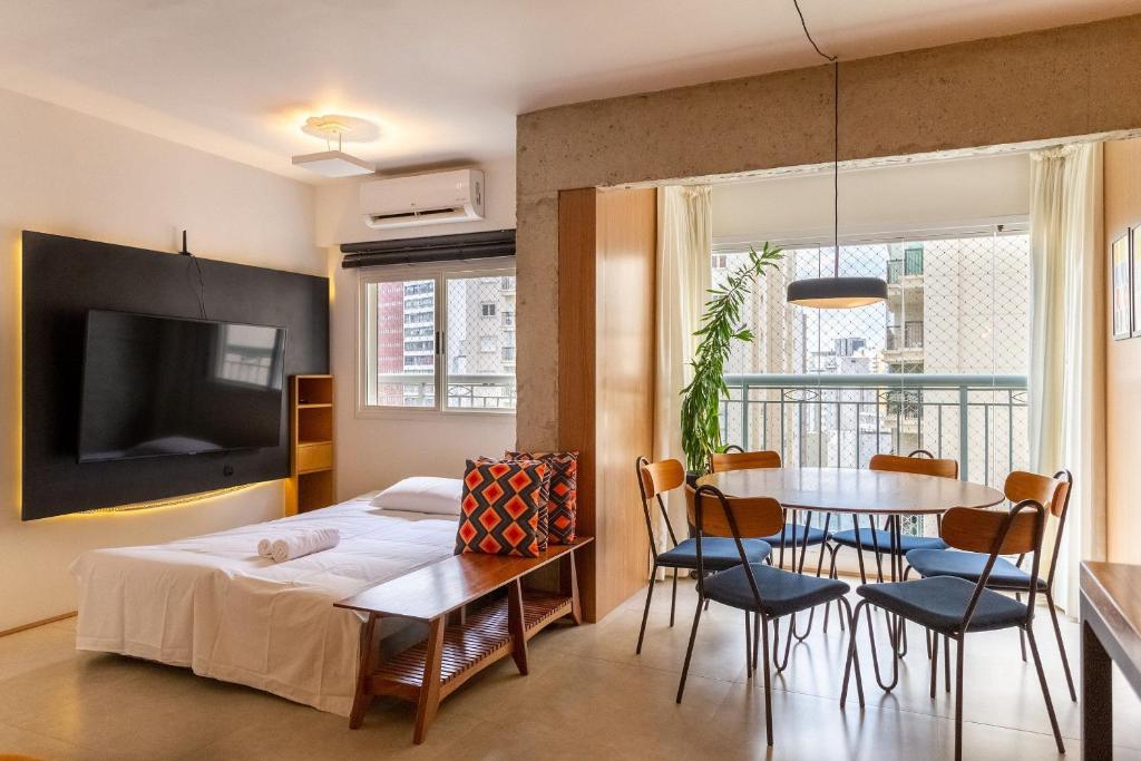 a bedroom with a bed and a table and chairs at Apto com máquina de lavar perto do metrô Trianon in Sao Paulo