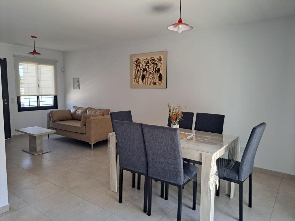 a dining room with a table and chairs and a couch at MODERNO DUPLEX Con COCHERA in Luzuriaga