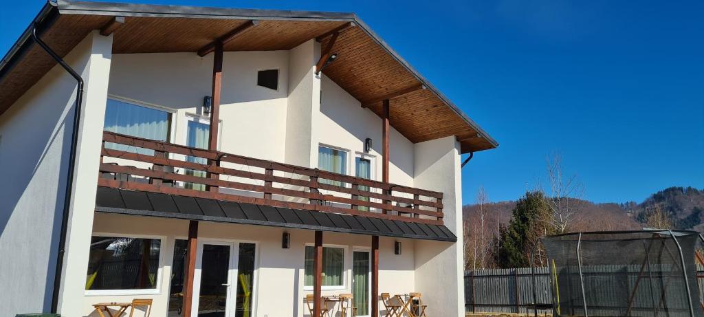 a house with a balcony with tables and chairs at Cabana Floare de Colt 2 in Râşnov