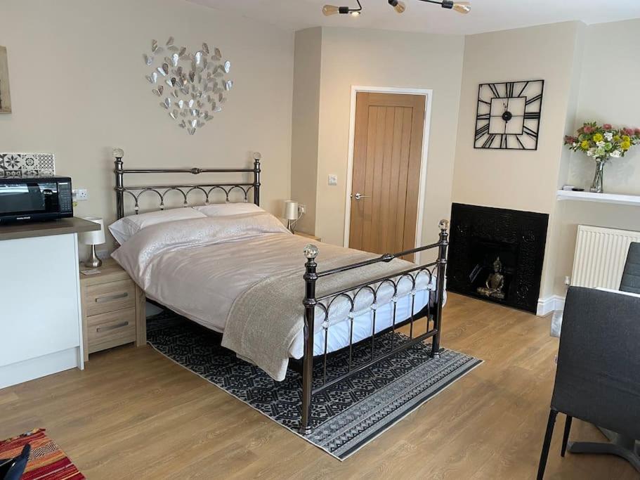 a bedroom with a large bed and a fireplace at Studio 2 in Matlock