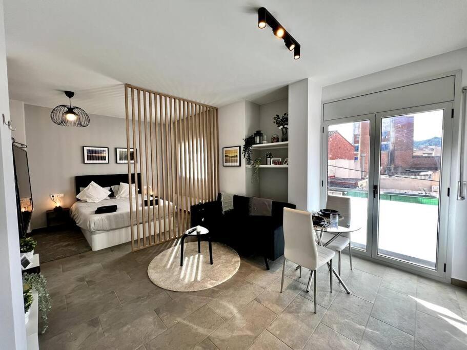 塔拉薩的住宿－Loft moderno en buena ubicación，一间带一张床的客厅和一间带桌子的房间