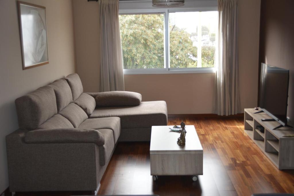 uma sala de estar com um sofá e uma televisão em Apartamento complejo residencial em Las Palmas de Gran Canaria