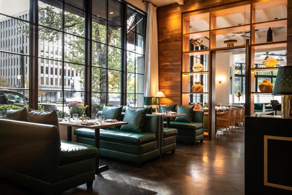 a restaurant with green furniture and large windows at Eurostars St Gregory Dupont Circle Georgetown in Washington