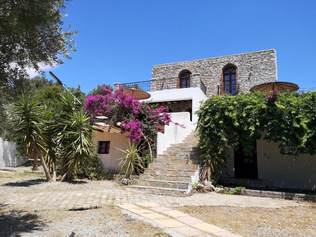 a house with purple flowers on the stairs at Blue Stone in Triopetra
