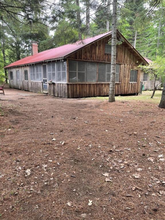 a large wooden building with a red roof at MACKINNEY CAMP - LIMIT 8 cottage in Standish