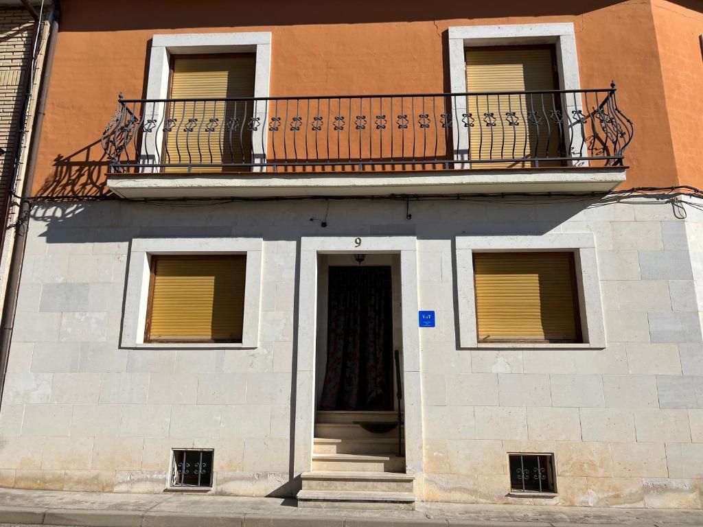 a building with a balcony and a door at EL COTARRO DE PESQUERA in Pesquera de Duero