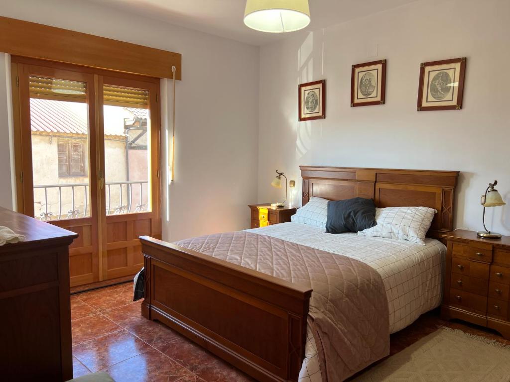 a bedroom with a large bed and a window at Casa Rural EL COTARRO DE PESQUERA DE DUERO in Pesquera de Duero