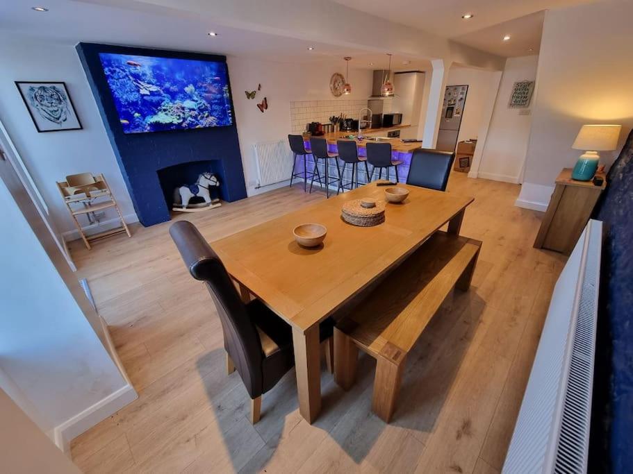 una mesa de madera y sillas en la sala de estar. en Cheerful 3 bedroom home with garden!, en Torquay