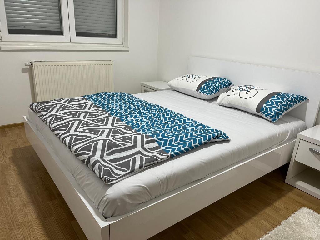 a bed with blue and white blankets and pillows at HG apartment in Jelah