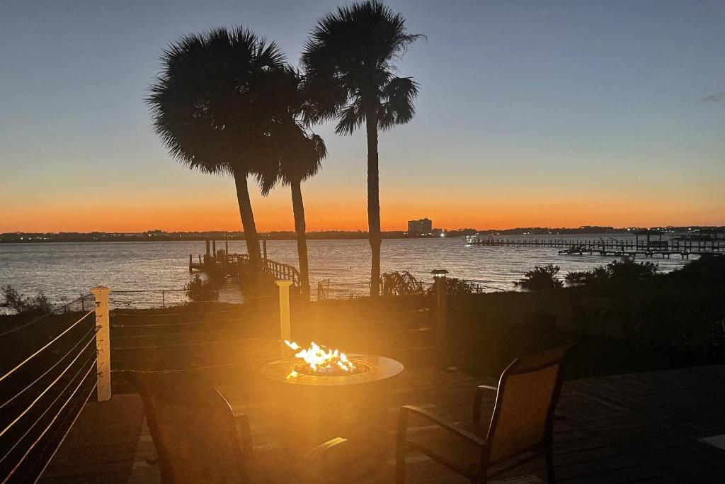 a sunset with palm trees and a table with a fire at 3170 S Peninsula Drive in Daytona Beach