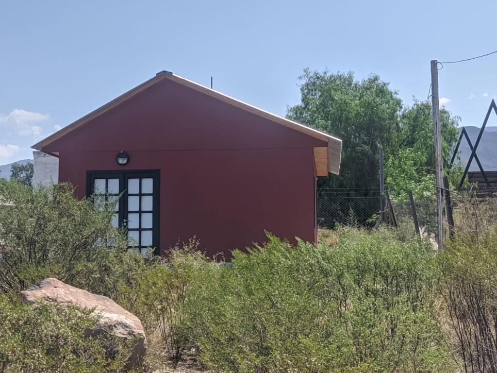 mały czerwony dom pośrodku pola w obiekcie Casa Cerro Arco w mieście Mendoza