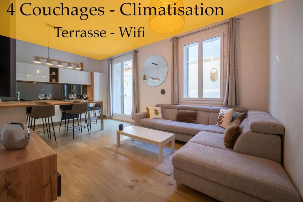 uma sala de estar com um sofá e uma mesa em Appartement climatisé grande terrasse 2 chambres em Marselha