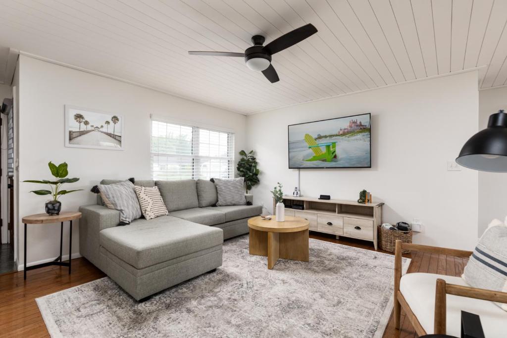 a living room with a couch and a ceiling fan at Palm House~Heated Pool~8 min to Beach in Largo