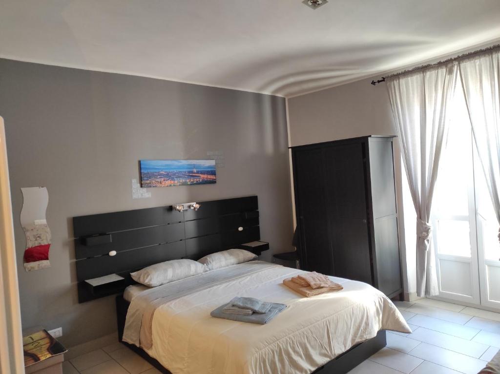 a bedroom with a large bed and a large window at Cinecasa di Andrea e Cristina in Turin