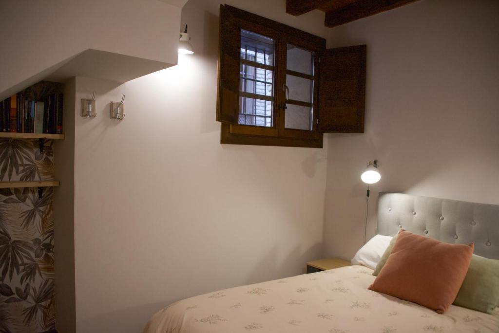 een slaapkamer met een bed en een raam bij Calle de las Bulas - Judería in Toledo