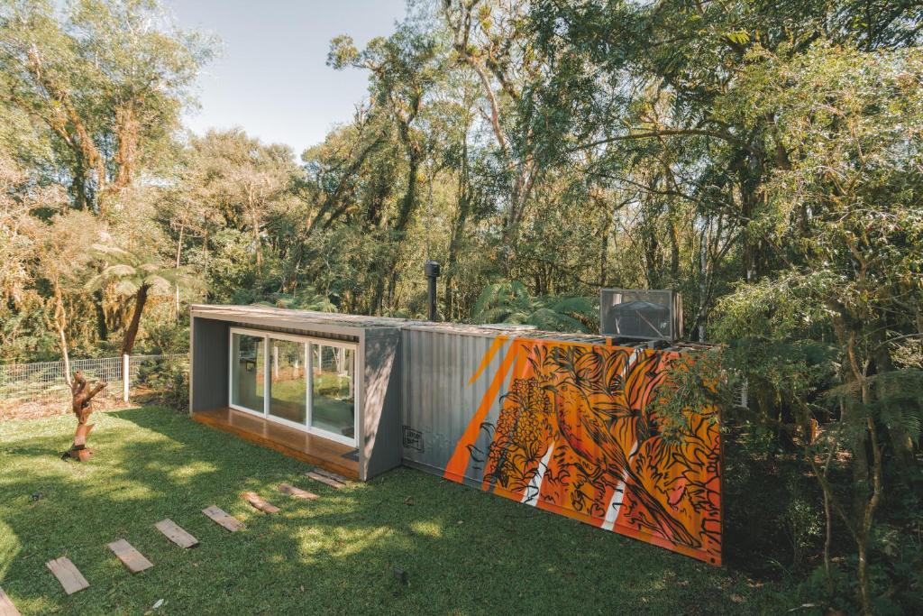 ein winziges Haus mit einem Wandbild an der Seite in der Unterkunft KŌN - Pousada Romântica in São Francisco de Paula