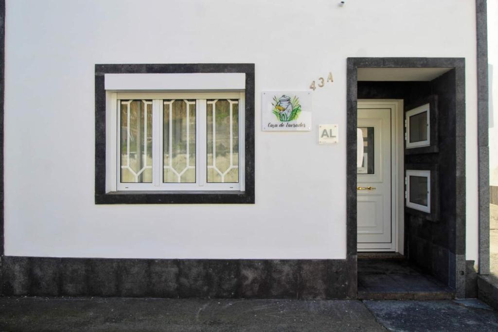 un edificio bianco con una porta e una finestra di Casa do Lavrador a Ponta Delgada