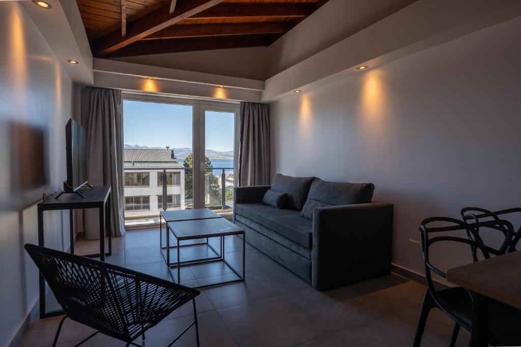 a living room with a couch and a large window at Portales de la Patagonia Apartments in San Carlos de Bariloche