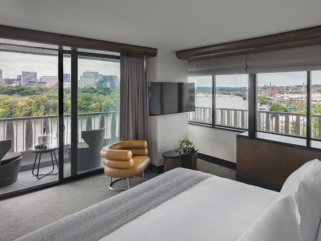 a hotel room with a large bed and a balcony at The Watergate Hotel Georgetown in Washington, D.C.