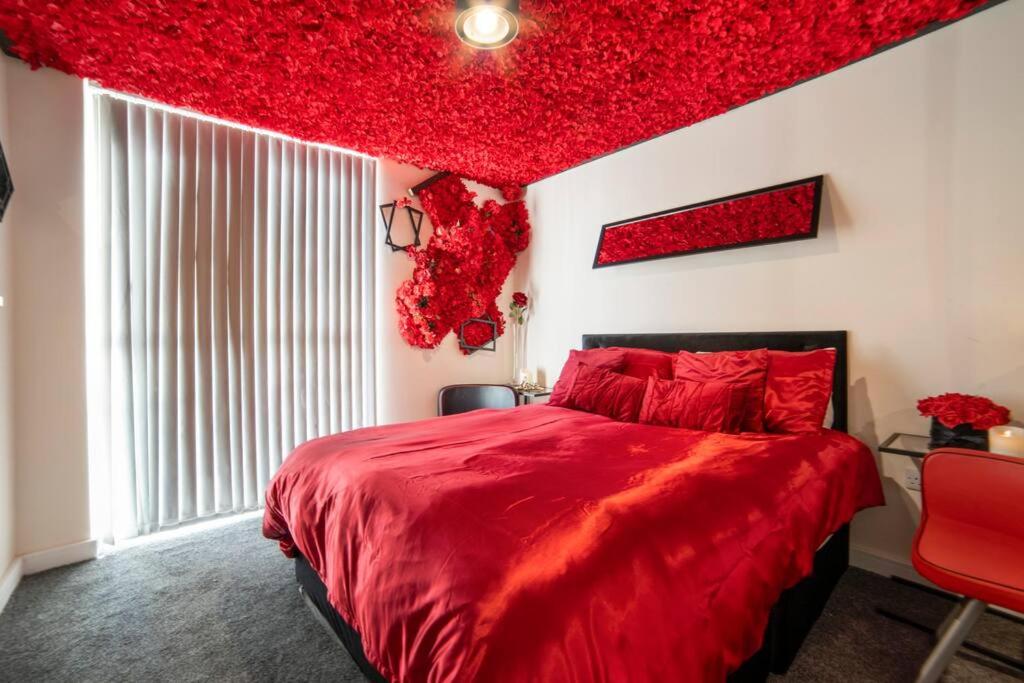 a bedroom with a red bed and a red ceiling at Romance in Leicester City Center in Leicester