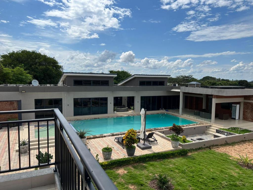 an exterior view of a house with a swimming pool at Exclusive Farm Getaway in Lusaka