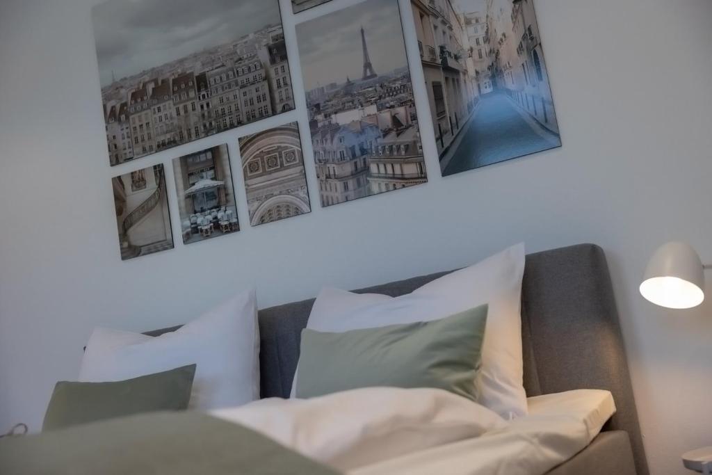 uma sala de estar com um sofá e quadros na parede em Kaza Guesthouse, centrally located 2 & 3 bedroom Apartments in Augsburg em Augsburg