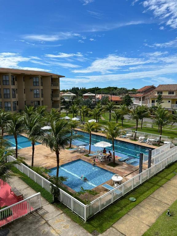 an overhead view of a pool with palm trees and buildings at Condado Aldeia dos Reis 311 in Mangaratiba