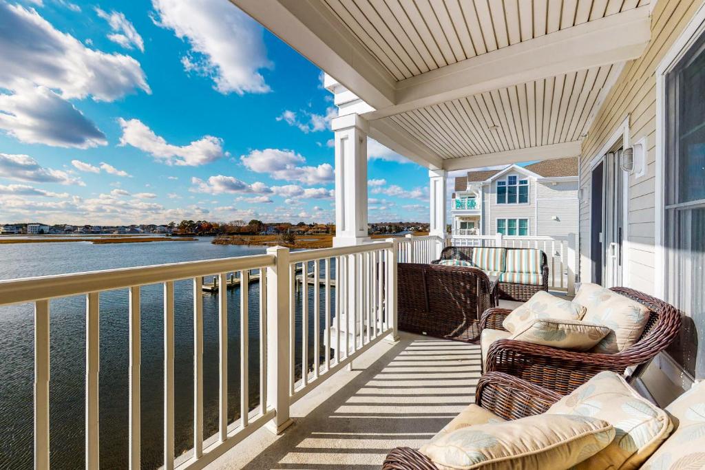 a balcony with chairs and a view of the water at Laguna Bay - 37292 Lighthouse #201 in Selbyville