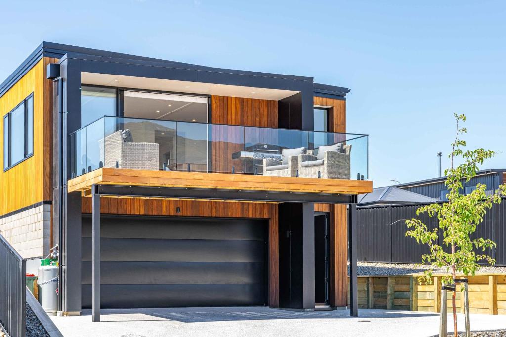 una casa moderna con un garage di fronte di Stylish Panoramic Mountain and Lake Views a Wanaka