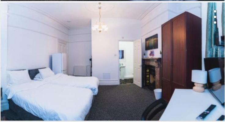 a hotel room with two beds and a fireplace at Howard House in Southampton