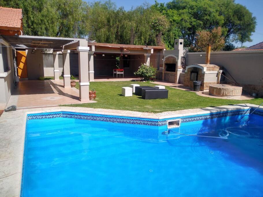 une grande piscine bleue devant une maison dans l'établissement Casa El Encuentro, à La Cieneguita