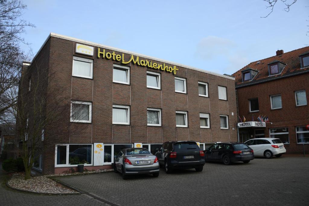 a hotel with cars parked in front of a building at Hotel Marienhof Düsseldorf Neuss in Neuss
